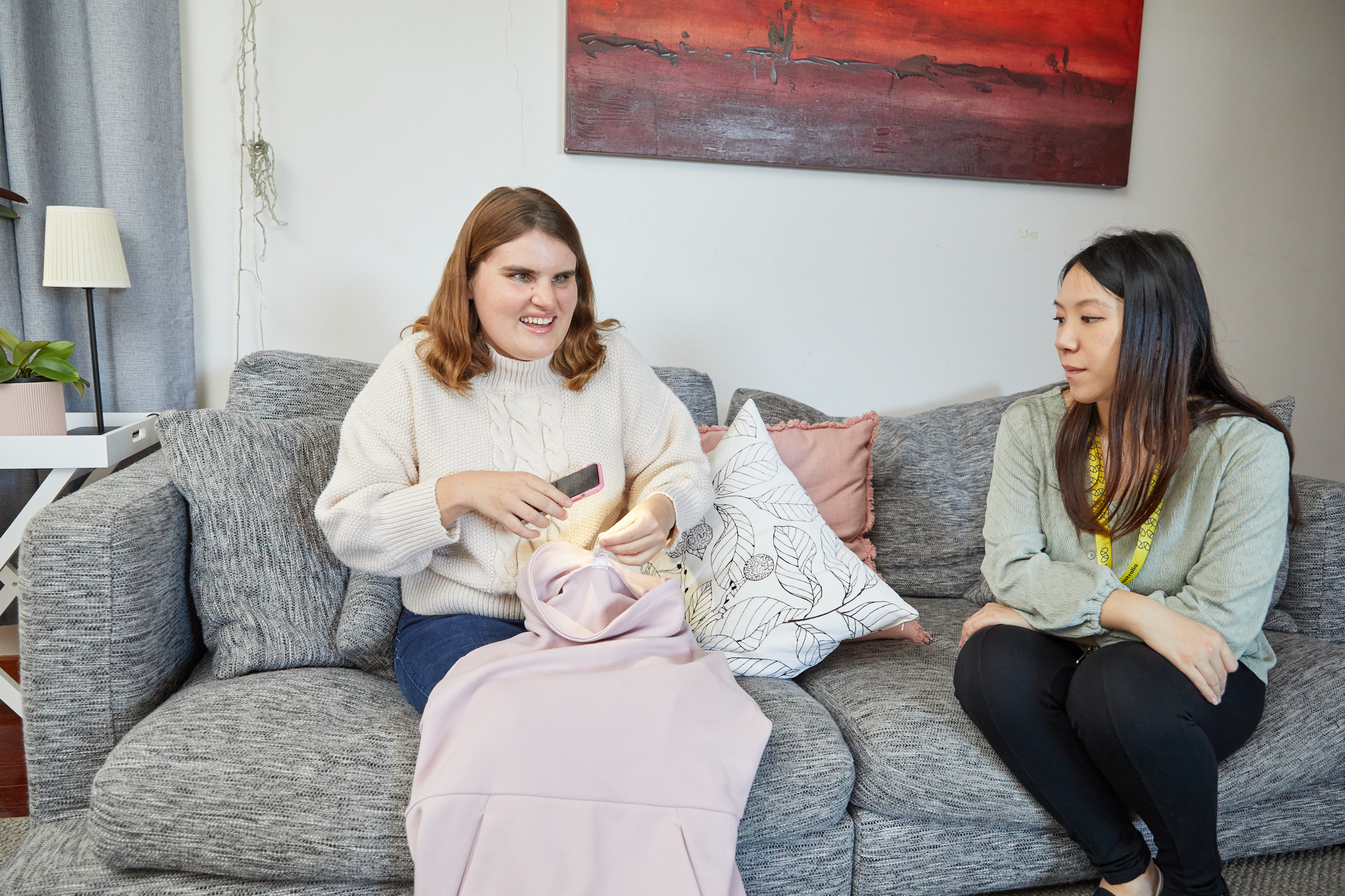 Two women sit on a lounge