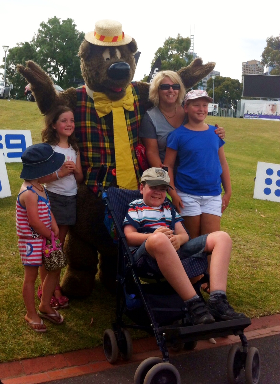 Humphrey B Bear with a family of four at Carols rehearsal