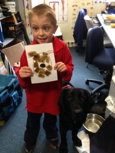 Young student proudly shows us his artwork of Faith the labrador