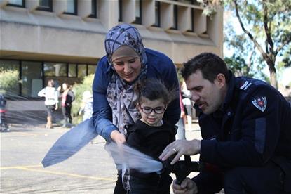 Wahiba Bakkour, VA Client Ayah Bakkour and Fire and Rescue's Samuel Monaghan use a fire hose