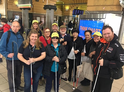 Image shows a group of Vision Australia clients with their white canes