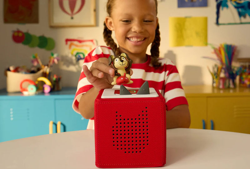 Young girl with a Tonies audio toy system including a tonies character and a toniebox